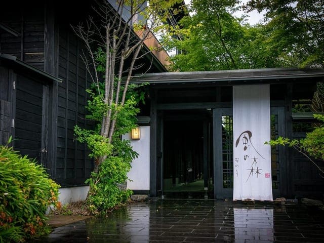 黒壁に暖簾の掛かる入口