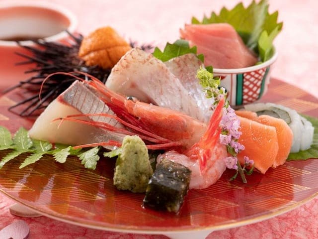 夕食のお造り。赤絵の硝子皿に甘えび・うに・鯛など日本海の旬が彩りよく盛られている
