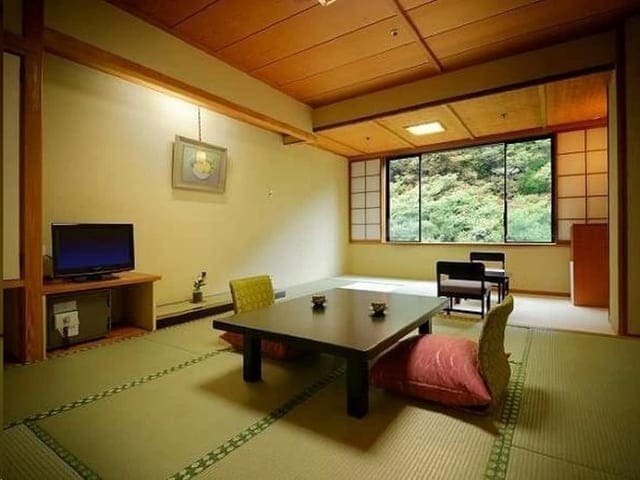 和室8畳。障子を開けた窓の外に木々が茂る