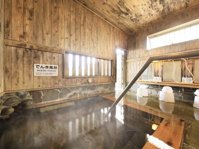木造の内湯。湯気が立ちのぼり、高い窓から光が差す