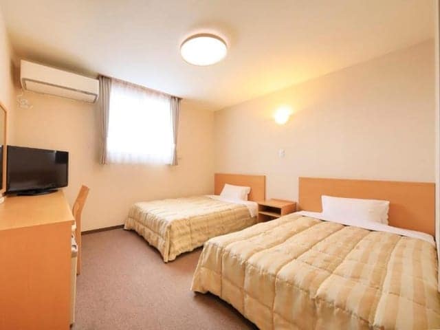 ツインの客室。白い寝具のベッドが2台並ぶ