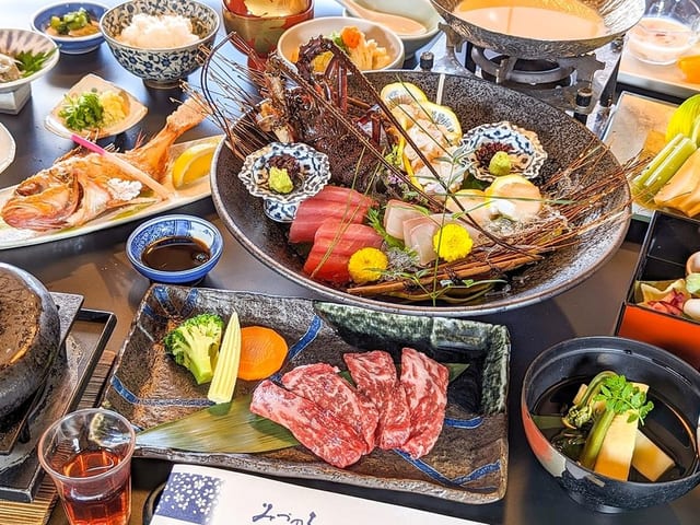 白帝懐石。造りと小鍋、前菜が卓一面に並ぶ