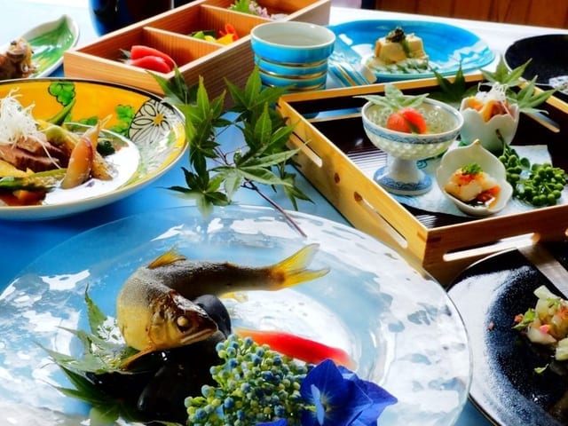 夕食の一例。舟形の器に造りが盛られ、小鉢と焼き物が並ぶ