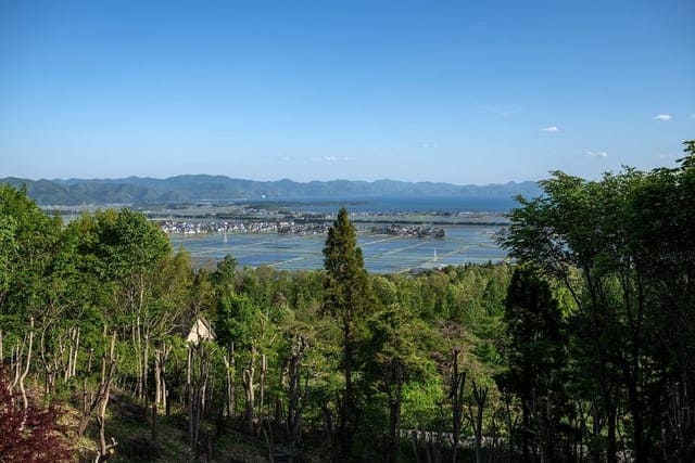 ラウンジから望む猪苗代湖。手前の木立の先に湖面と対岸の山並みが広がる