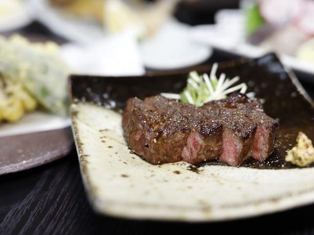 夕食の一例。豊後の和牛を焼き上げた一皿が織部の器に盛られている