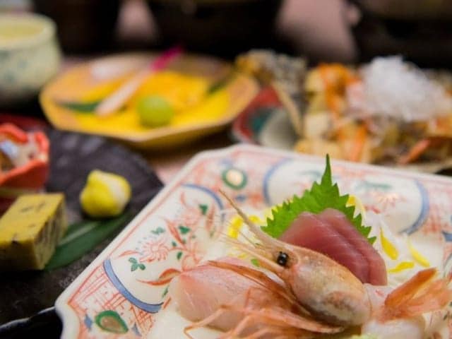 和食会席膳。刺身の盛り合わせを中心に、小鉢と揚げ物が並ぶ