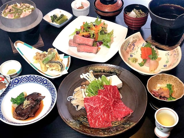 信濃路会席。牛肉の陶板と造り、小鉢が卓に並ぶ
