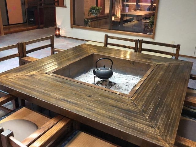 囲炉裏端のロビー。炉を囲む席が並び、湯上がりにくつろげる