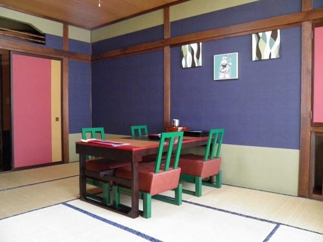 広縁付きの和室。紺色の壁に朱の襖が並ぶ