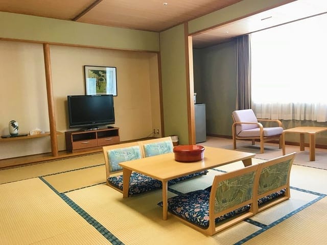 10畳の和室。畳に座卓を置き、障子越しに外光が入る