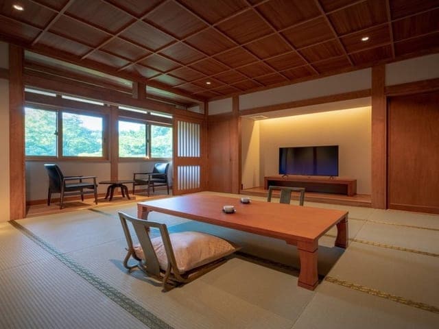 広い和室。障子と窓に沿って座卓が置かれている