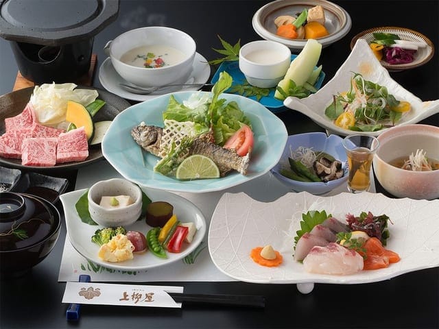 夕食の一例。造りと小鉢、天ぷらが卓に並ぶ
