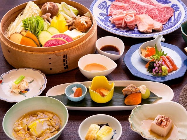 夕食の一例。せいろ蒸しと牛肉の皿、小鉢が並ぶ