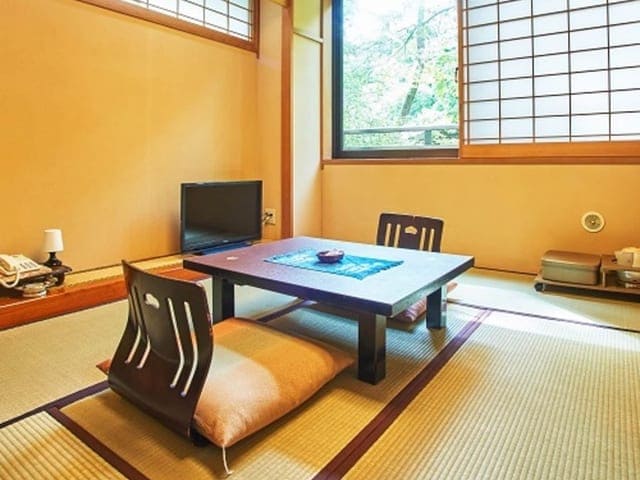 渓谷側の6畳和室。障子と窓の先に木々が見える