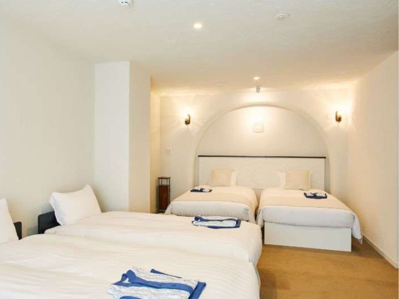 キャプテンズツインルームは白とベージュを基調とし、赤をアクセントに入れたお部屋。3、4名で対応可能でご家族利用にもおすすめです。4名利用時はエキストラベッドが2つ入ります。