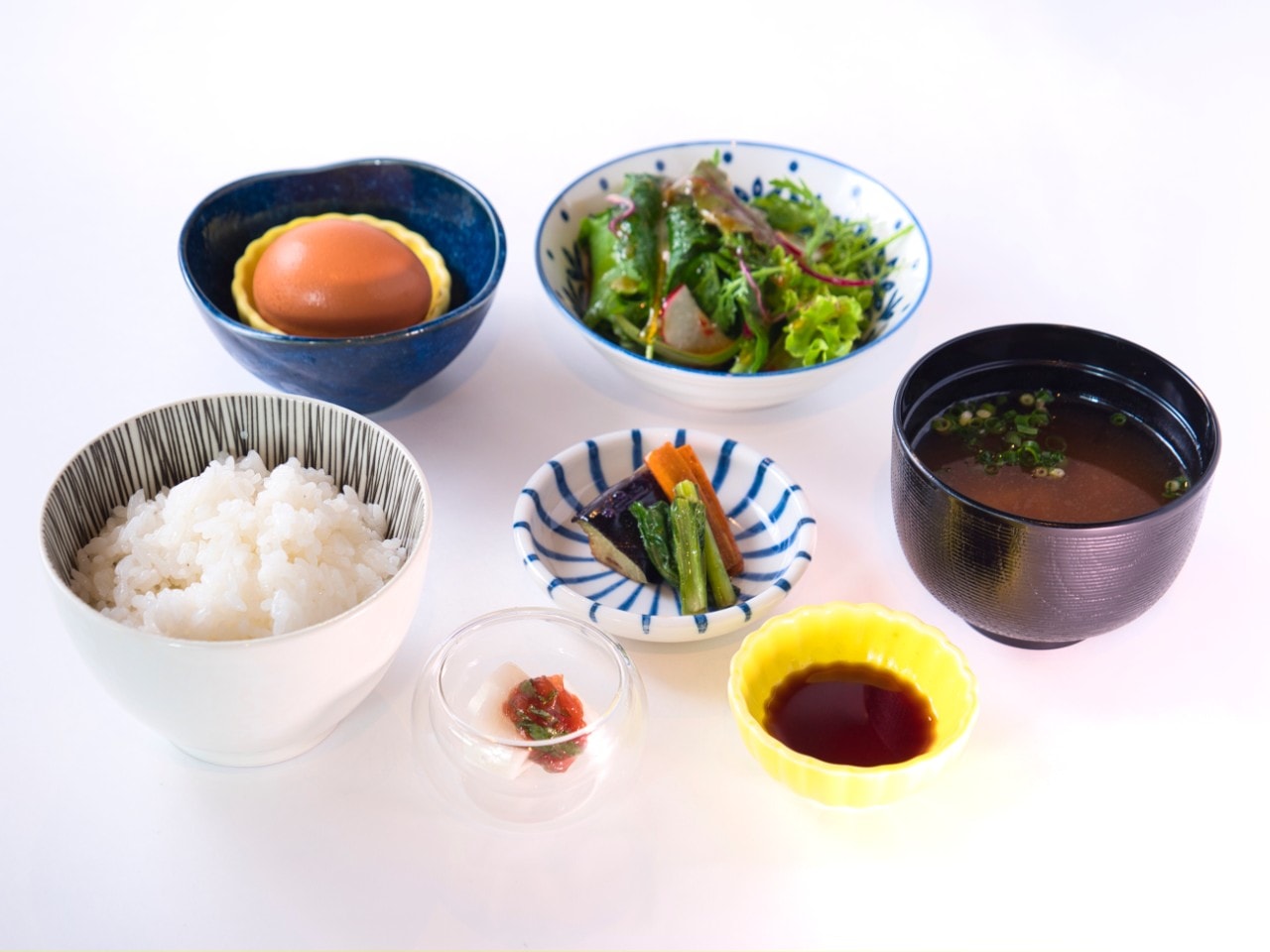 本松さんの「ゆう地卵」玉子かけ朝ごはん■ (440円税込)極上卵をダイレクトに味わえるTKG。引き立て役のお惣菜や漬物等全て既製品は一切使用せず女性シェフの真心こもった手作りが並びます。